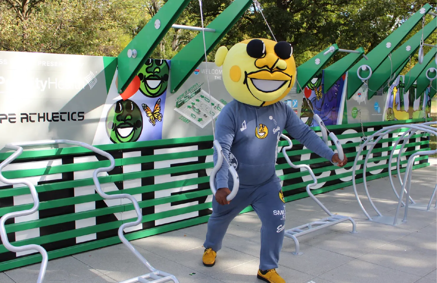 artist with custom costume on demonstrating how to use the Fitness Court